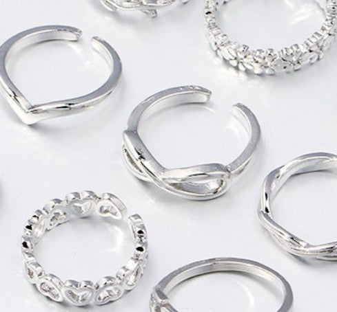 Collection of silver rings on a light background