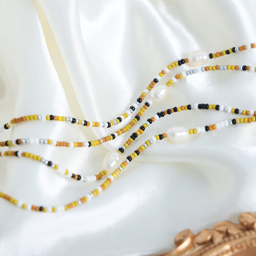 Mimosa multicolour bead necklace with yellow orange black white beads and central pearl