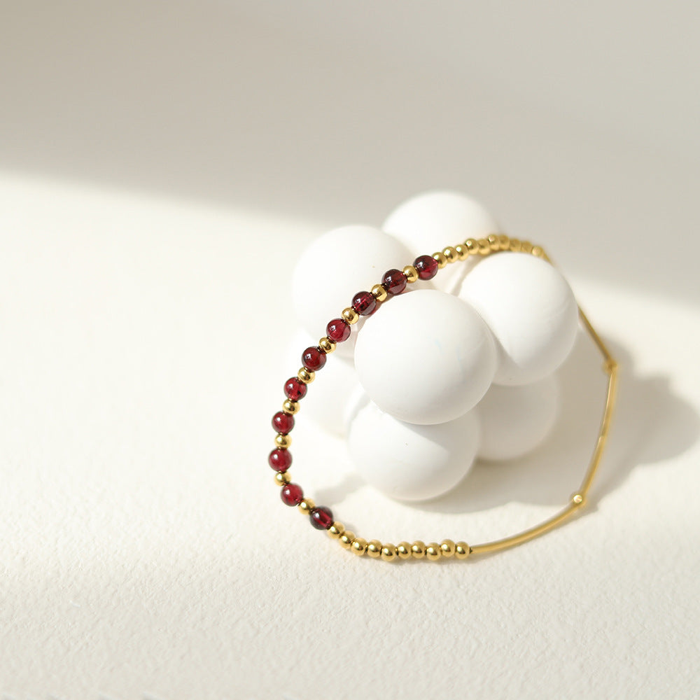 Delicate gold and garnet elastic bracelet by Wyldflower Jewellery